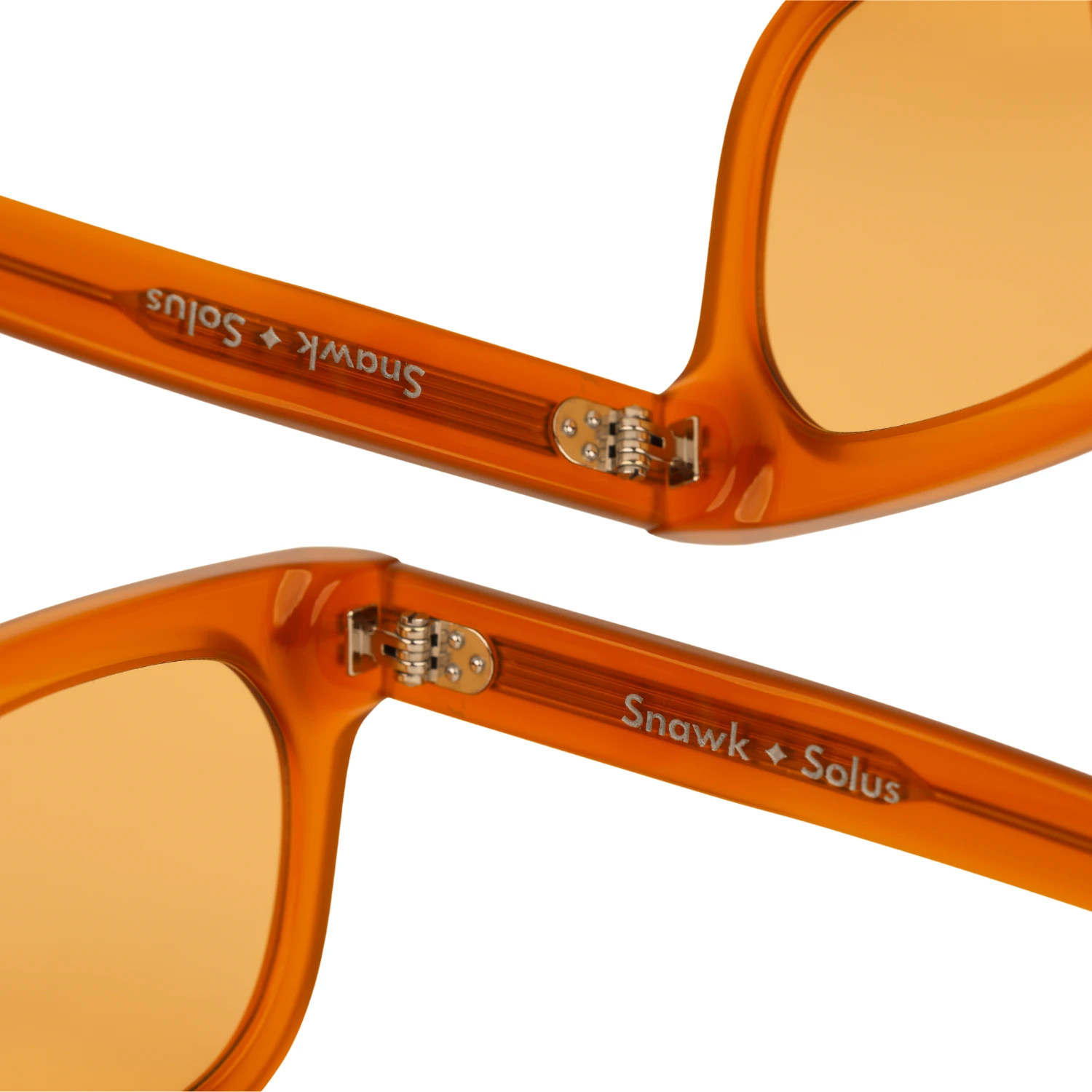 Close-up of the Amber Snawk Solus sunglasses showing the riveted metal hinge and the Snawk Solus inner temple marking